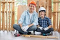 Asian father and son stay in their workplace of carpentering and look at camera with smiling. Asian family concept to stay at home