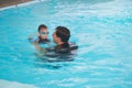 Asian Father and son takes a swimming lesson at swimming pool, Cute little Asian toddler boy child wearing swimming goggles Royalty Free Stock Photo