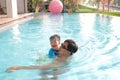 Asian Father and son takes a swimming lesson at swimming pool, Cute little Asian toddler boy child learning to swim with his dad Royalty Free Stock Photo