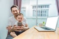 Asian father and son using smart phone together in home background. Technology and People concept. Lifestyles and Happy family th Royalty Free Stock Photo