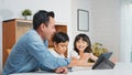 Asian father teach young son and daughter homework, using digital tablet at home. E-learning lifestyle Royalty Free Stock Photo