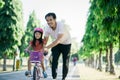 Father Teaching daughter To Ride Bike In the park Royalty Free Stock Photo