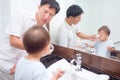 Asian Father teaching kid teeth brushing, Cute little 2 years old toddler boy child brushing teeth with dad in bathroom Royalty Free Stock Photo