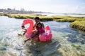 Asian father and two daughters ride flamingo buoy on the beach Royalty Free Stock Photo