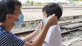 Asian father wearing medical face mask to child boy son to prevent from corona virus or covid-19 Royalty Free Stock Photo