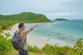 Asian fatty backpacker stand on view point on top of the island with idyllice beach ocean and blue sky in vacation time