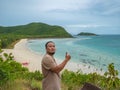 Asian fatty backpacker stand on view point on top of the island with idyllice beach ocean and blue sky in vacation time