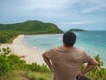 Asian fatty backpacker stand on view point on top of the island with idyllice beach ocean and blue sky in vacation time