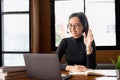 Asian female adult student in headphones using laptop, attending online lesson, virtual class, listening webinar Royalty Free Stock Photo