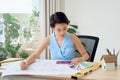 Asian Female architect working at home.She looking blueprints Royalty Free Stock Photo