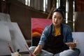 Asian Female Artist Draws create art piece with palette and brush painting at studio. Royalty Free Stock Photo