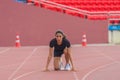 Asian female athlete at start block, ready for her speed running practice on the stadium track, epitomizing readiness Royalty Free Stock Photo