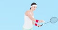 Asian female badminton player holding racket against light blue background Royalty Free Stock Photo