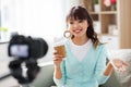 Asian female blogger with coffee recording video