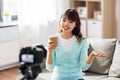 Asian female blogger with coffee recording video