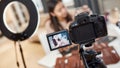 Remain social. Asian female blogger showing cosmetic products while recording a tutorial video for her beauty blog using Royalty Free Stock Photo