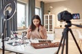 Redefine beauty. Asian female blogger showing cosmetic products while recording a tutorial video for her beauty blog Royalty Free Stock Photo