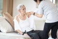 Asian female caregiver taking care of helping elderly patient get dressed,wearing clothes or undressing for senior mother, Royalty Free Stock Photo