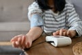 An Asian female checking her blood pressure and heart rate with blood pressure monitor by herself Royalty Free Stock Photo