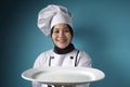 Asian Female Chef Shows Empty White Plate, Presenting Something, Copy Space Royalty Free Stock Photo