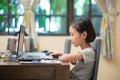 Asian female child doing online learning or e-learning at home