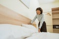 Asian female cleaning staff tidying pillows on bed Royalty Free Stock Photo