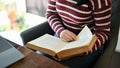 Asian female college student reading a book while sitting in the campus library. cropped image Royalty Free Stock Photo