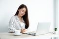 Asian female college students study online at home, enjoy extra lessons, watch videos, and take notes from a digital laptop, do