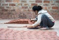 Asian female crafswoman processing ceramic brick