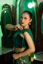 an Asian female dancer with a green dance costume and a sexy body posing very agilely while dancing Royalty Free Stock Photo