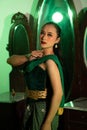 an Asian female dancer with a green dance costume and a sexy body posing very agilely while dancing Royalty Free Stock Photo