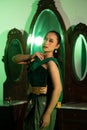 an Asian female dancer with a green dance costume and a sexy body posing very agilely while dancing Royalty Free Stock Photo