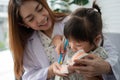 Asian female dentist teaching cute little girl brushing teeth with toothbrush and stomatologist telling girl child about oral