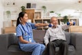 Asian female doctor advice elderly patient to physiotherapist to exercise with dumbbell at home.Smiling nurse helping senior