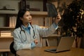 Asian Female Doctor Analyzing X-Ray Results in Medical Office During Evening Hours Royalty Free Stock Photo
