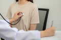 Asian female doctor checking heart rate listening to chest of young female patient with stethoscope in clinic Royalty Free Stock Photo