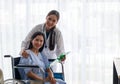 Asian female doctor cheered on a female patient in a wheelchair in her room