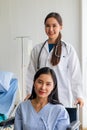 Asian female doctor cheered on a female patient in a wheelchair in her room