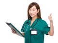 Asian female doctor with clipboard and thumb up Royalty Free Stock Photo