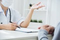 Asian Female Doctor discussing with patient. Royalty Free Stock Photo