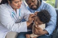 Asian female doctor doing a preliminary examination in the ear of a 10-month-old Nigerian baby boy Royalty Free Stock Photo