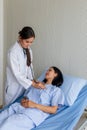 Asian female doctor examined the patient on a bed in the room