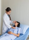 Asian female doctor examined the patient on a bed in the room