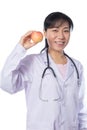 Asian female doctor holding apple with stethoscope Royalty Free Stock Photo