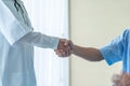 Asian female doctor at the hospital or clinic giving an handshake to hre patient Royalty Free Stock Photo