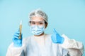 Asian female doctor, lab worker in personal protective equipment, showing thumbs up and test sample tube analise Royalty Free Stock Photo