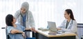 Asian female doctor monitoring checking up senior woman patient on wheelchair while Muslim Arab Islam wears hijab in white lab