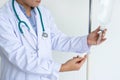 Asian female doctor preparing, testing, changing and adjusting infusion bottle in patient room.