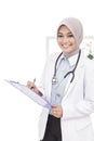 Asian female doctor with stethoscope smiling while writing down Royalty Free Stock Photo