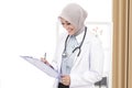 Asian female doctor with stethoscope writing down a note Royalty Free Stock Photo